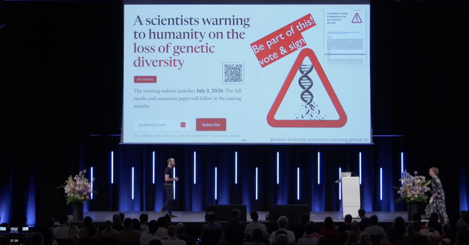 Moisés Expósito-Alonso delivering the SMBE Copenhagen plenary, with a slide announcing 'A scientists warning to humanity on the loss of genetic diversity' and a call to vote and sign, plus the site QR code and launch date.